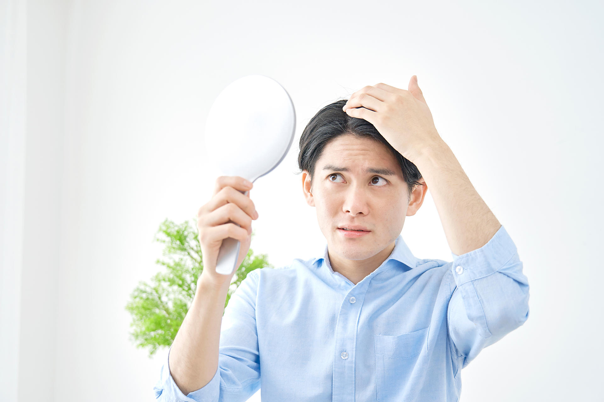 鏡を見る男性の画像